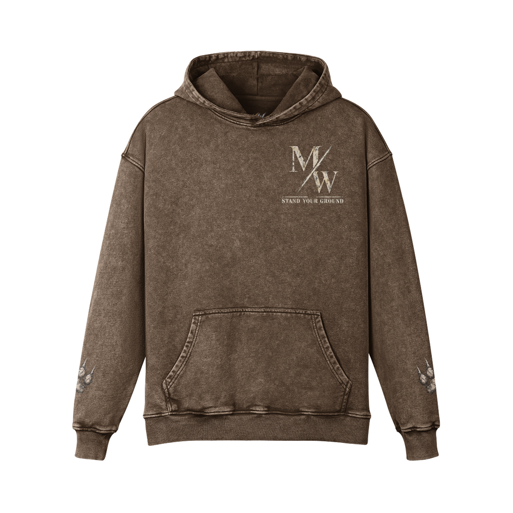 A brown acid-wash pullover hoodie with a distressed texture, featuring a white 'M/W STAND YOUR GROUND' graphic on the left chest and small white graphics on both sleeves, shown against a plain white background.